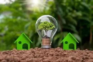 Rappresentazione di una lampadina e due modellini di casa che richiama il concetto di energia pulita e green